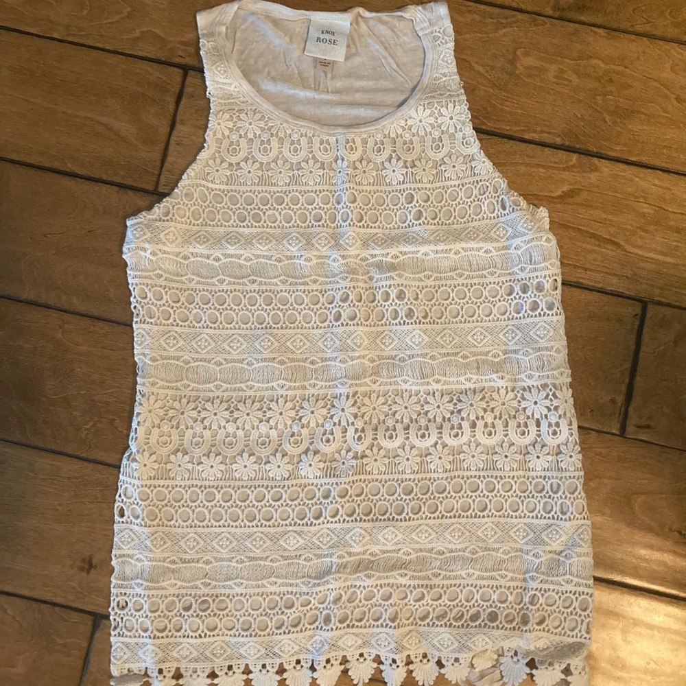 Cream colored tank top with a lace designed front